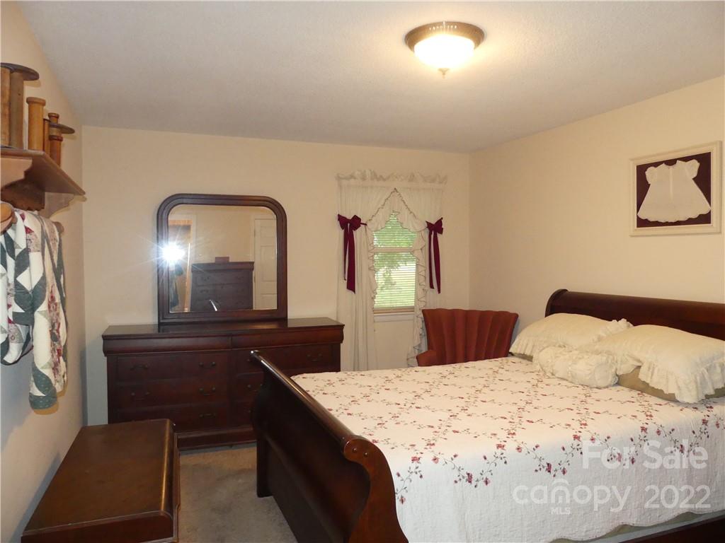 1319 Mooresboro Road Shelby, NC 28150 - Photo 18 of 27 a bedroom with a bed and a mirror on dresser