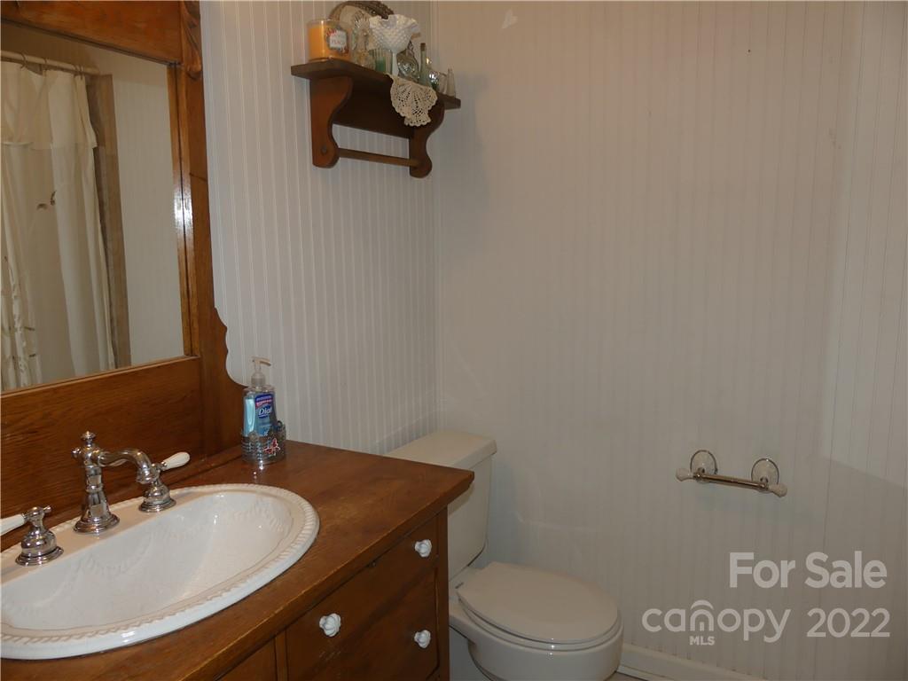 1319 Mooresboro Road Shelby, NC 28150 - Photo 21 of 27 a bathroom with a granite countertop sink a toilet and mirror