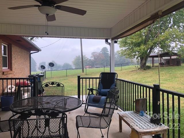 1319 Mooresboro Road Shelby, NC 28150 - Photo 24 of 27 a view of a patio with a table chairs and a floor to ceiling window