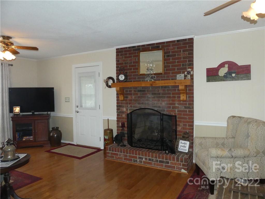 1319 Mooresboro Road Shelby, NC 28150 - Photo 8 of 27 a living room with furniture a flat screen tv and a fireplace
