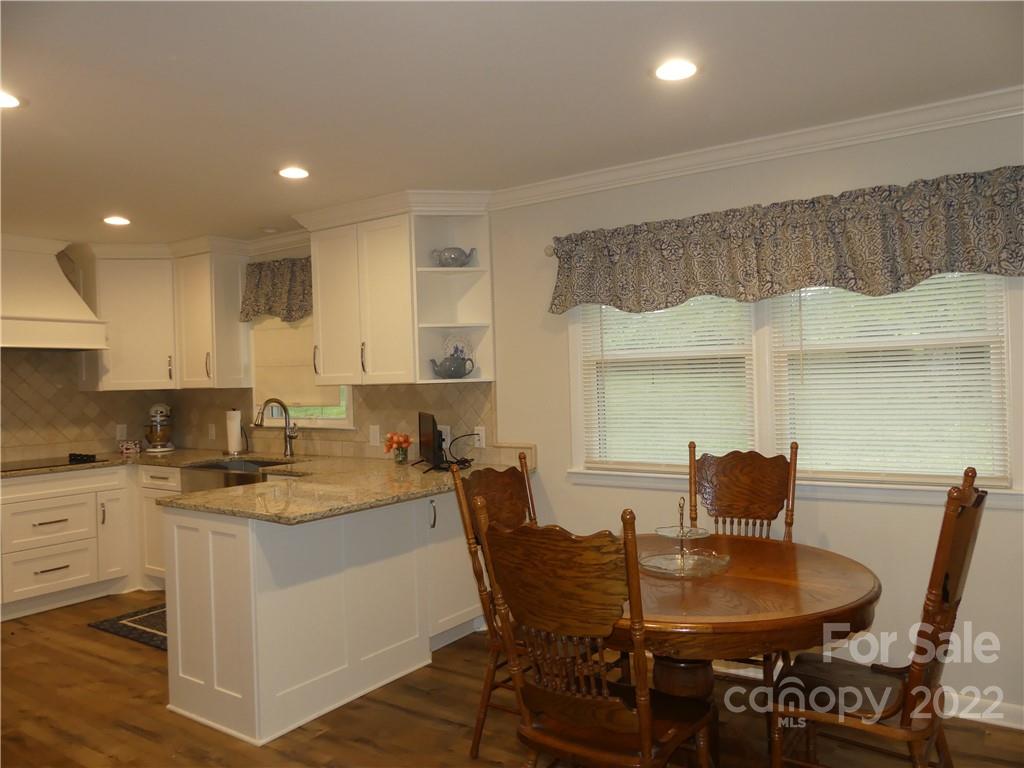 1319 Mooresboro Road Shelby, NC 28150 - Photo 10 of 27 a kitchen with a dining table chairs and white cabinets
