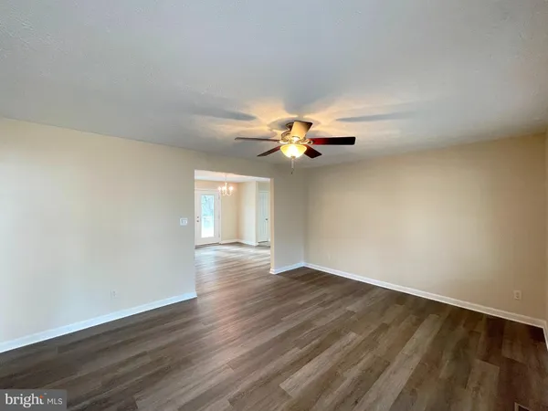 a view of an empty room with wooden floor
