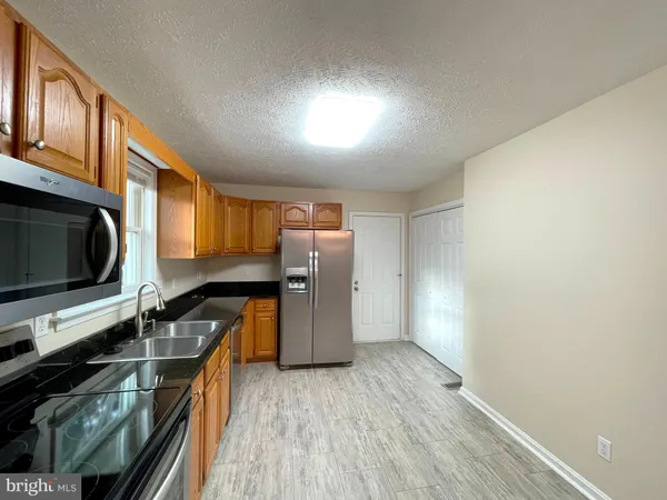 a kitchen with stainless steel appliances a refrigerator and a stove top oven