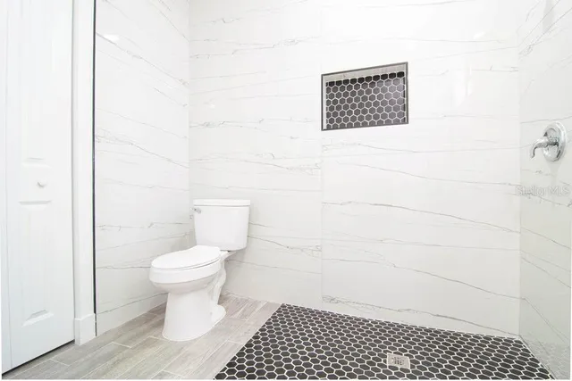 a bathroom with a toilet a sink and a shower