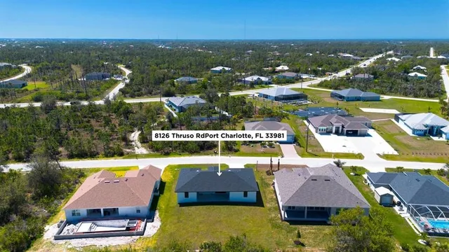an aerial view of residential houses with outdoor space and swimming pool