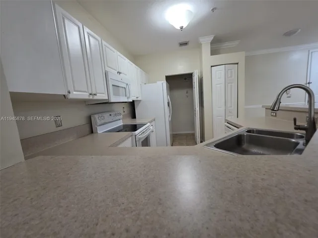 a kitchen with stainless steel appliances granite countertop a sink a refrigerator and a granite counter tops