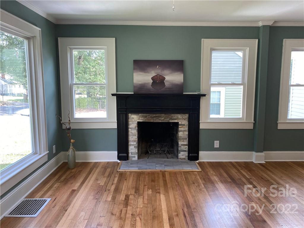 706 Kings Road Shelby, NC 28150 - Photo 4 of 25 a view of an empty room with wooden floor a fireplace and a window