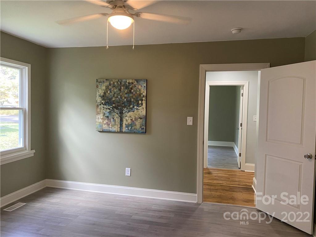 706 Kings Road Shelby, NC 28150 - Photo 9 of 25 an empty room with wooden floor fan and windows