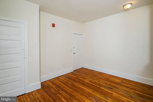 a view of a room with wooden floor and white walls