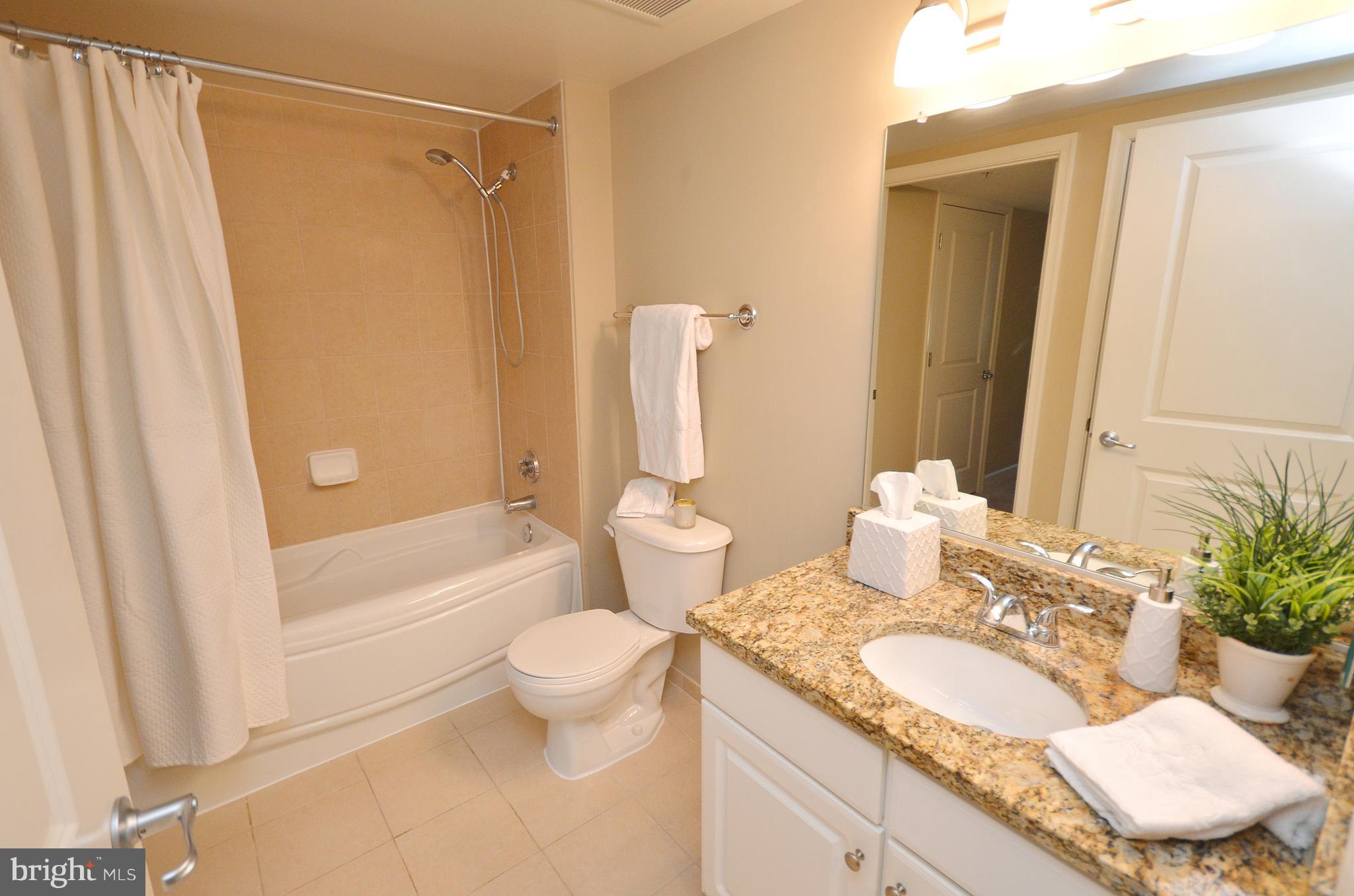 11800 Sunset Hills Road, Unit 210 Reston, VA 20190 - Photo 17 of 30 a bathroom with a granite countertop sink toilet and shower