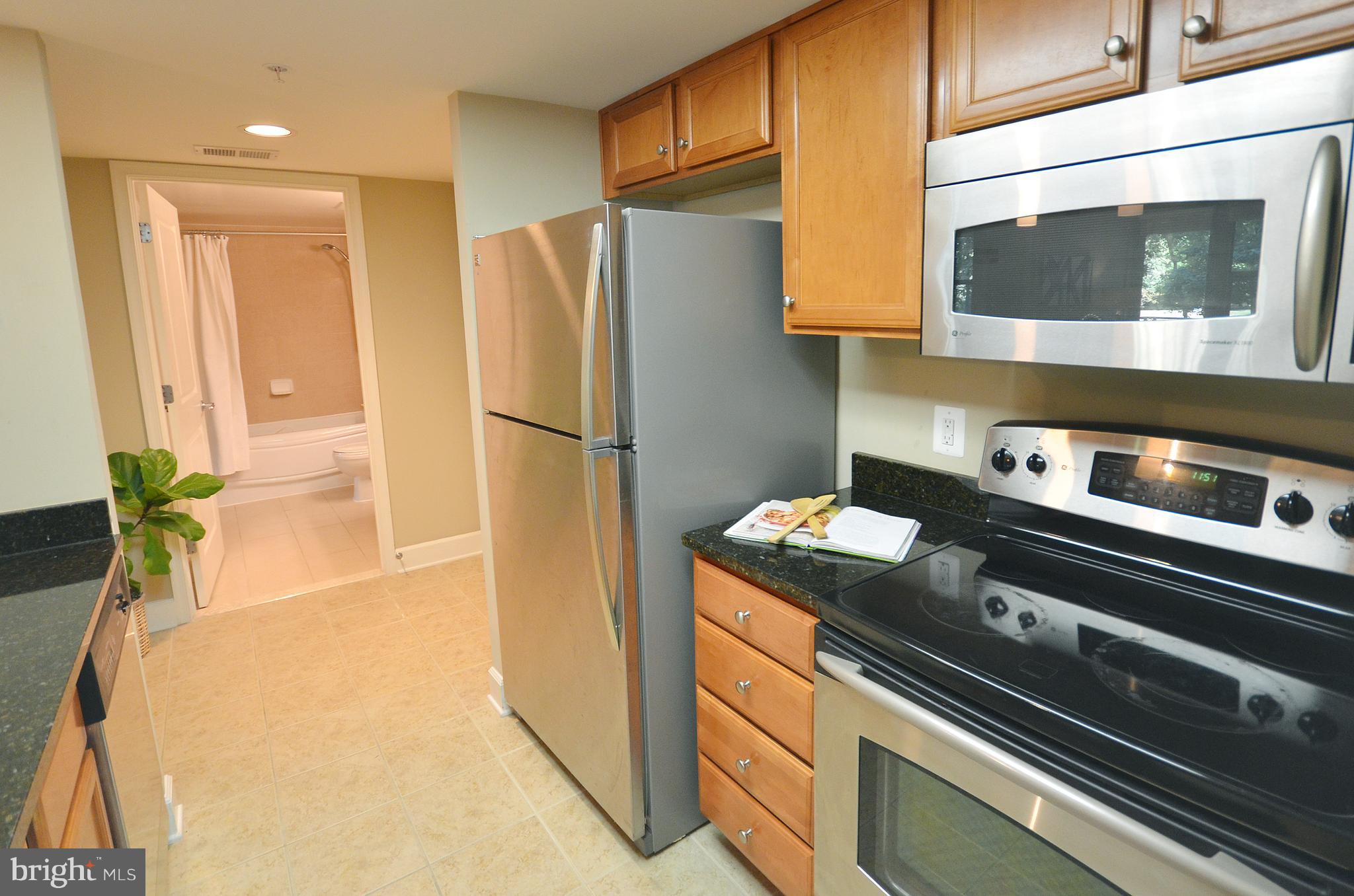 11800 Sunset Hills Road, Unit 210 Reston, VA 20190 - Photo 5 of 30 a kitchen with stainless steel appliances a refrigerator a stove a microwave and cabinets
