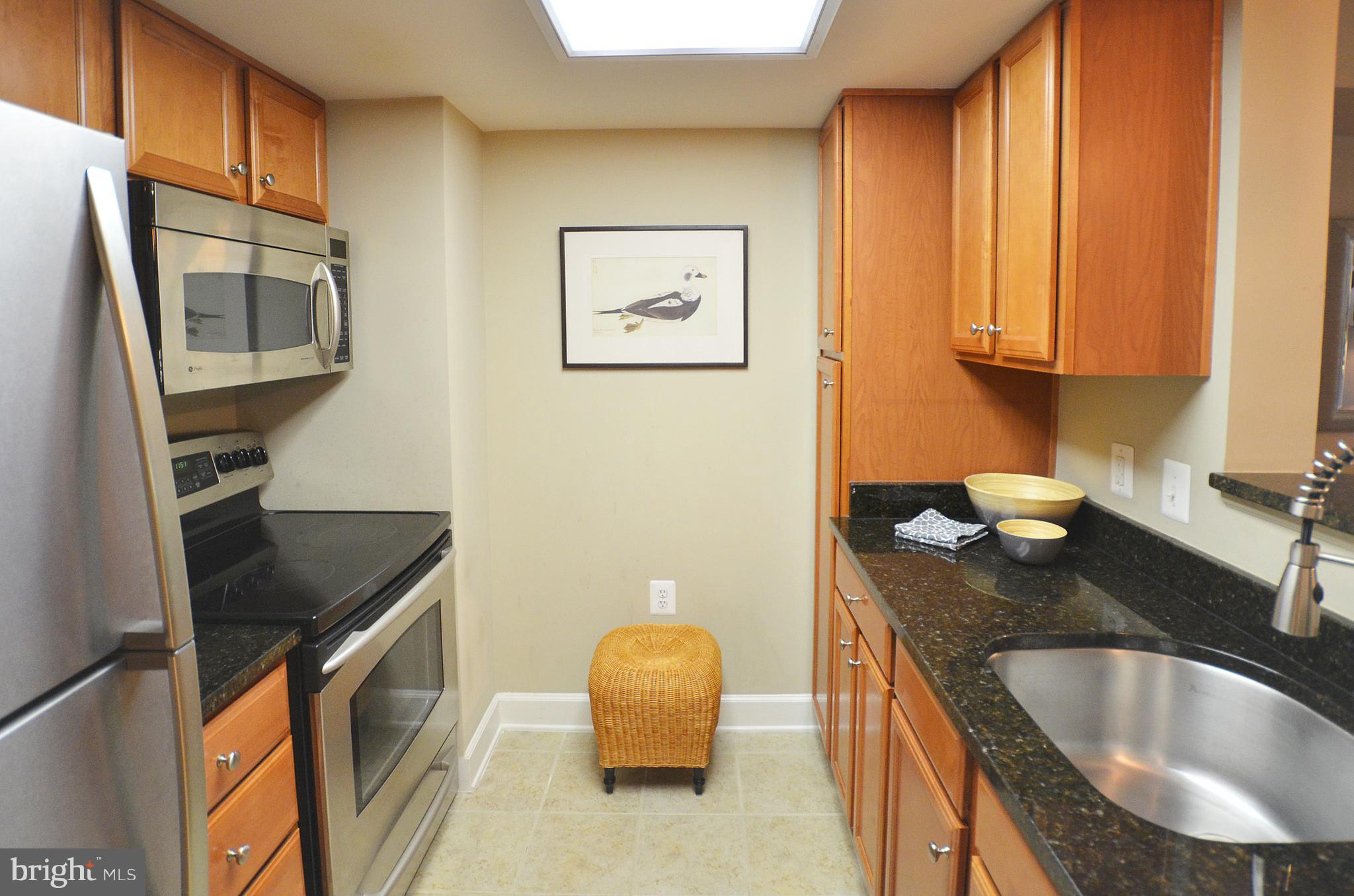 11800 Sunset Hills Road, Unit 210 Reston, VA 20190 - Photo 8 of 30 a kitchen with granite countertop a sink a stove and a refrigerator