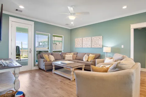 a dining hall with stainless steel appliances granite countertop a stove a sink a dining table and chairs with wooden floor