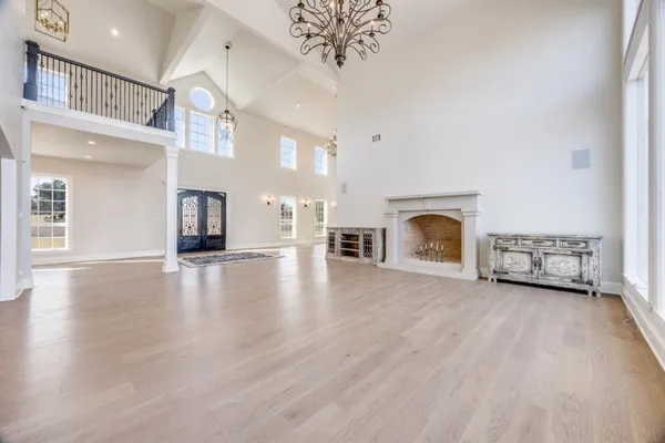 a view of a livingroom with a fireplace a chandelier and wooden floor