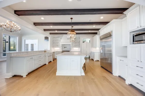 a kitchen with stainless steel appliances kitchen island granite countertop a refrigerator and a stove