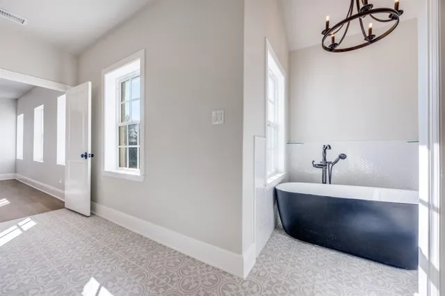 a bathroom with a bathtub and chandelier
