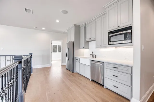 a kitchen with white cabinets stainless steel appliances and sink