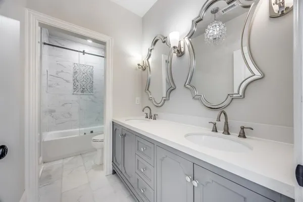 a bathroom with a double vanity sink mirror and toilet
