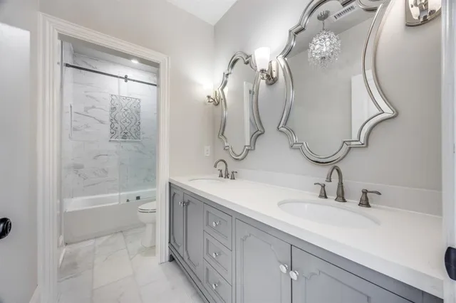 a bathroom with a double vanity sink mirror and toilet