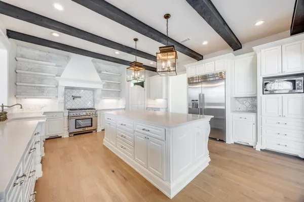a kitchen with stainless steel appliances a stove refrigerator and cabinets