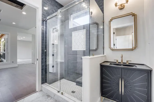 a bathroom with a shower sink and mirror