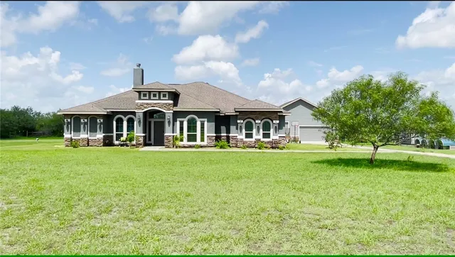 a front view of a house with a garden