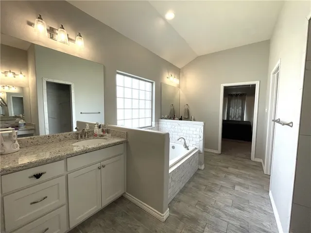 a spacious bathroom with a granite countertop sink and a mirror