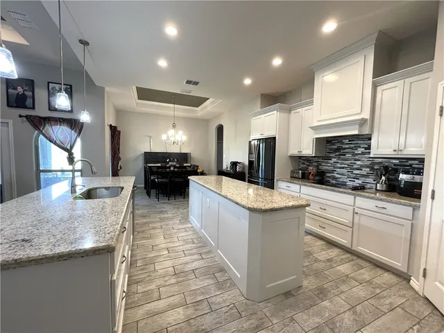 a kitchen with kitchen island granite countertop lots of counter top space and stainless steel appliances