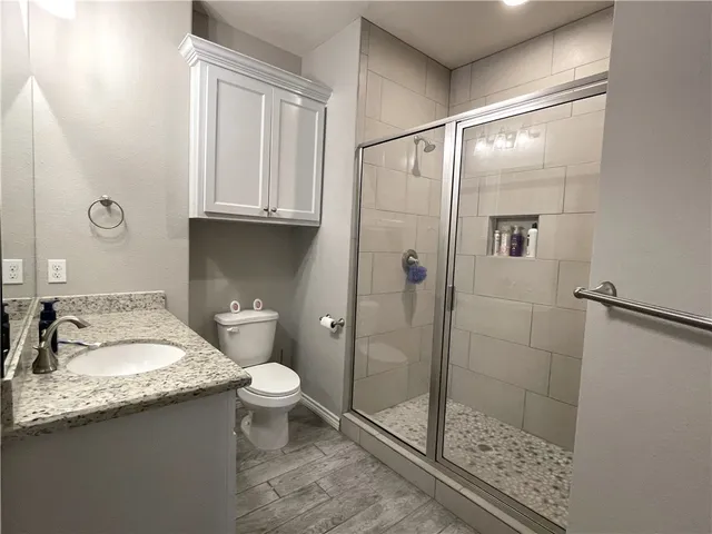 a bathroom with a granite countertop sink toilet and shower