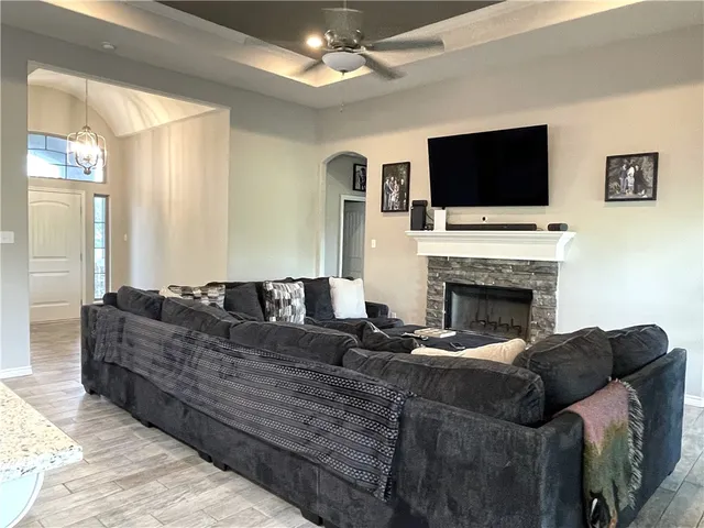 a living room with furniture a flat screen tv and a fireplace