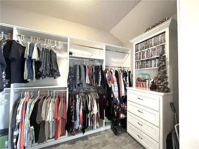 a view of walk in closet with clothes and shoes