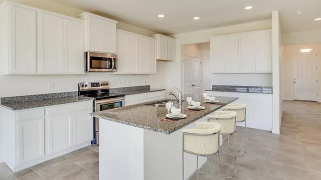 a kitchen with stainless steel appliances granite countertop a sink and white cabinets
