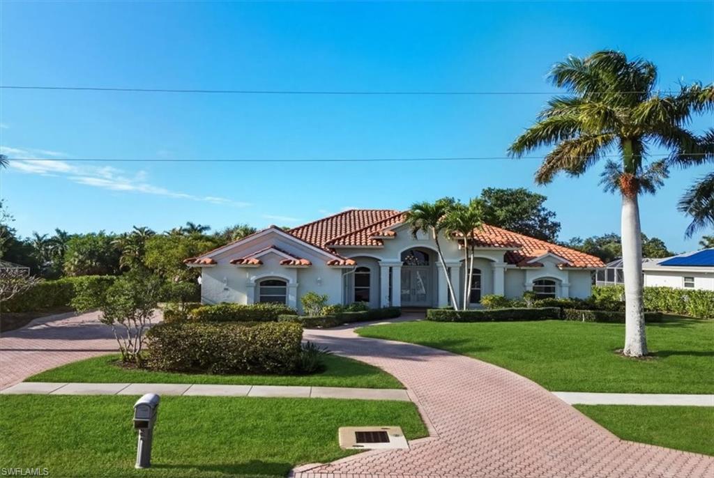Mediterranean / spanish-style home with a front lawn, decorative driveway, and stucco siding