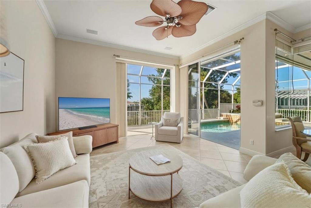 560 Inlet Drive Marco Island, FL 34145 - Photo 13 of 32 Tiled living area with a sunroom, ornamental molding, and ceiling fan