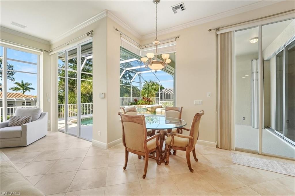 560 Inlet Drive Marco Island, FL 34145 - Photo 16 of 32 Tiled dining space featuring ornamental molding and a chandelier