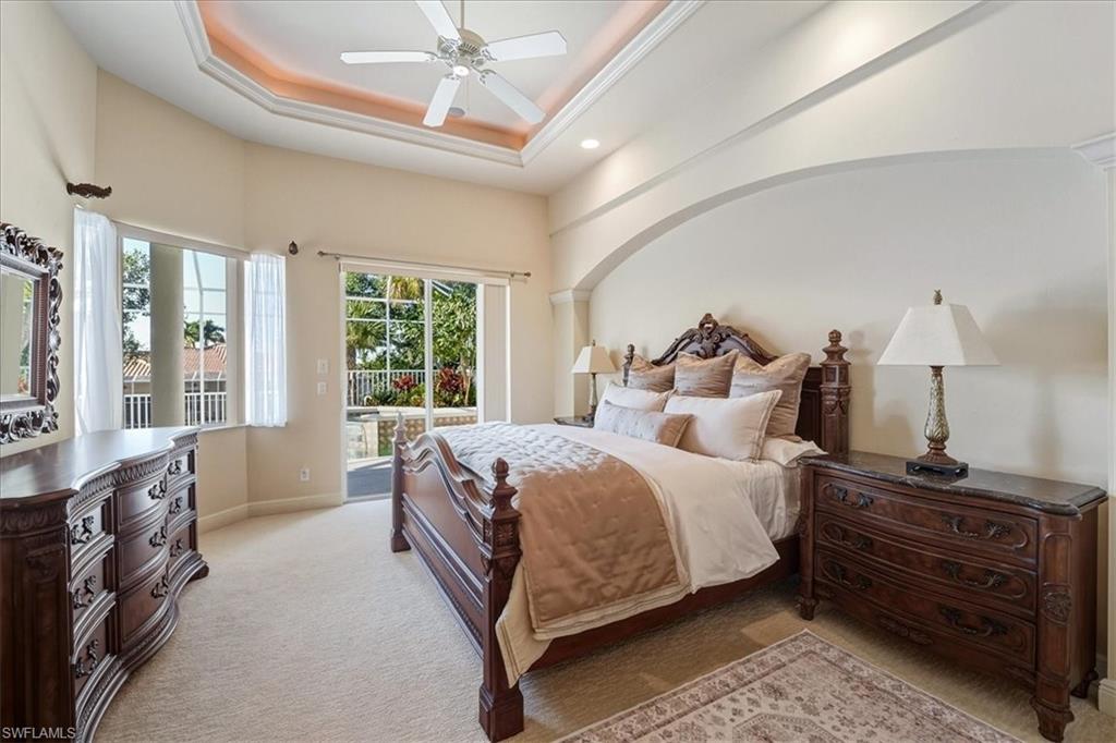 560 Inlet Drive Marco Island, FL 34145 - Photo 17 of 32 Bedroom with light carpet, a tray ceiling, ceiling fan, and access to exterior