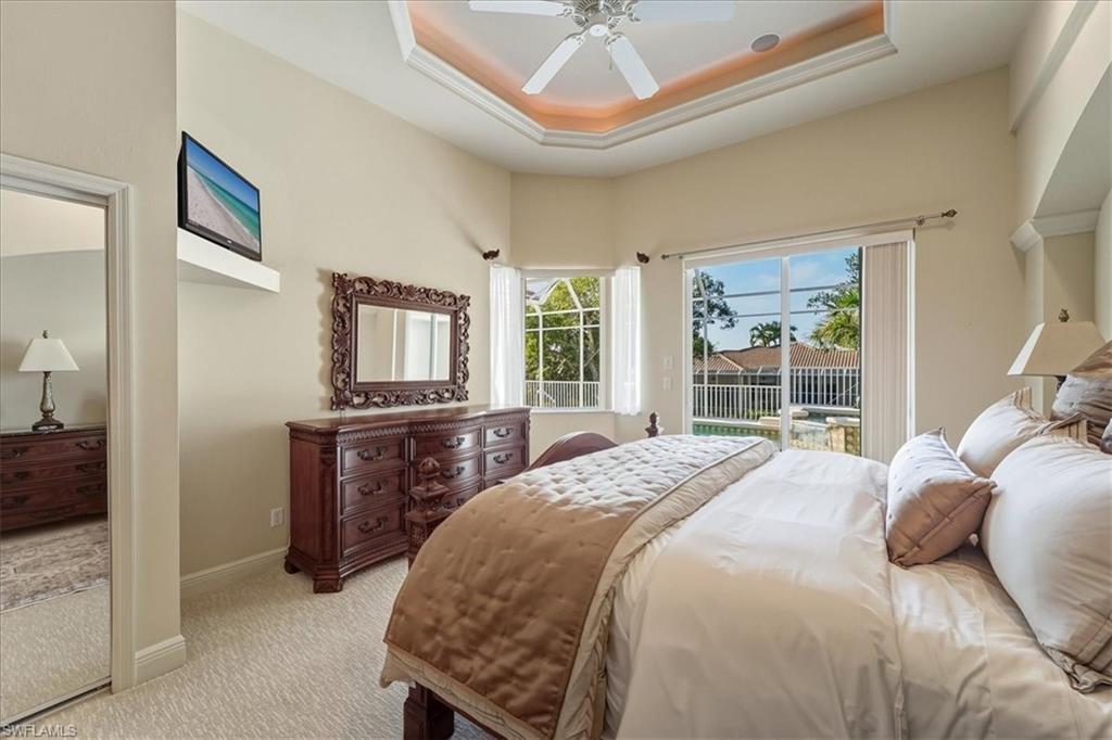 560 Inlet Drive Marco Island, FL 34145 - Photo 18 of 32 Bedroom with access to exterior, a raised ceiling, carpet floors, and a ceiling fan