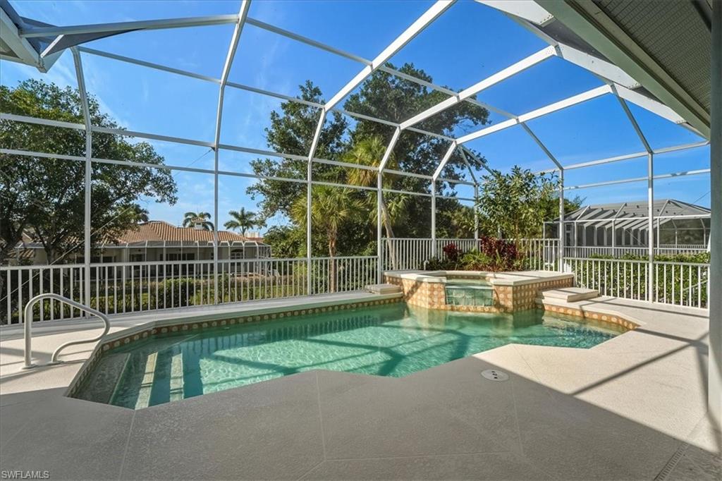 560 Inlet Drive Marco Island, FL 34145 - Photo 26 of 32 View of pool with glass enclosure, a sunroom, a patio area, and a pool with connected hot tub