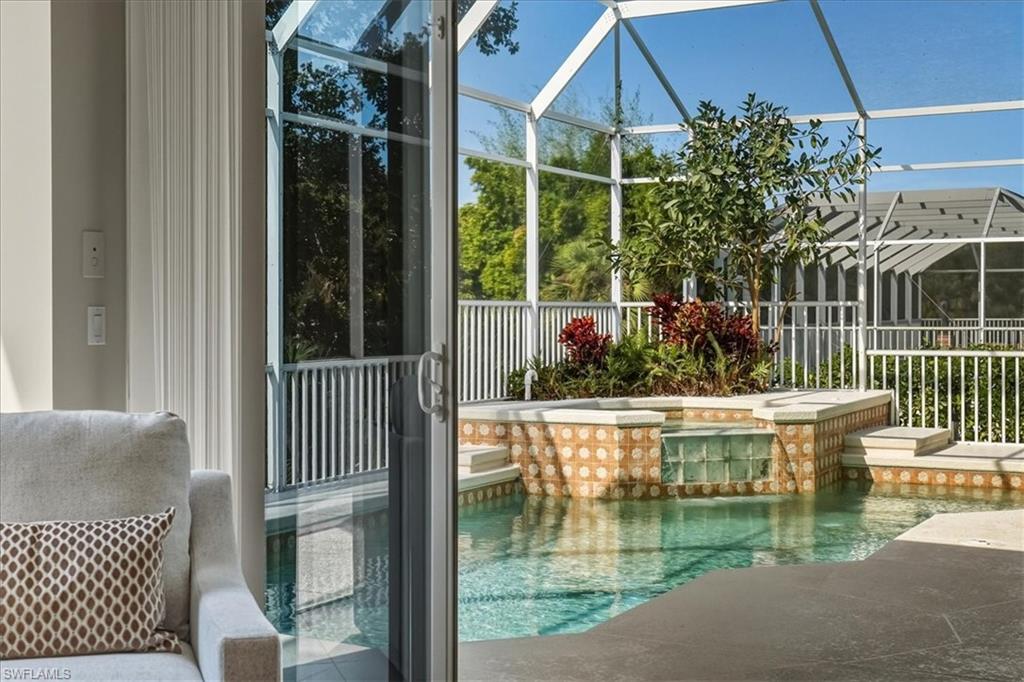 560 Inlet Drive Marco Island, FL 34145 - Photo 5 of 32 Swimming pool with a lanai, a patio area, a sunroom, and an in-ground hot tub