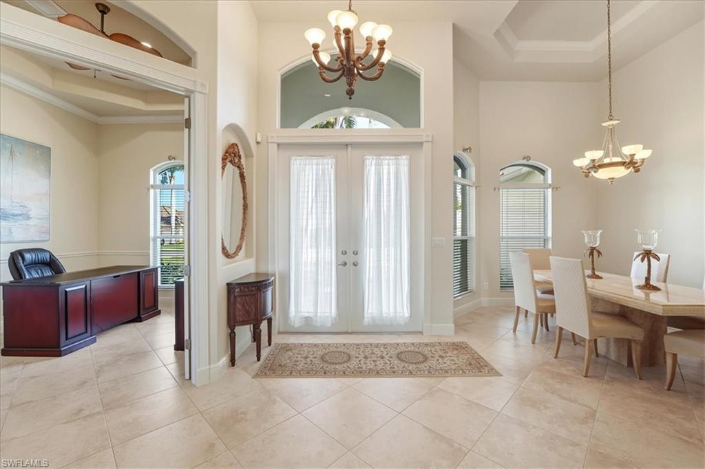 560 Inlet Drive Marco Island, FL 34145 - Photo 6 of 32 Foyer entrance with a chandelier, french doors, crown molding, a towering ceiling, and light tile patterned flooring