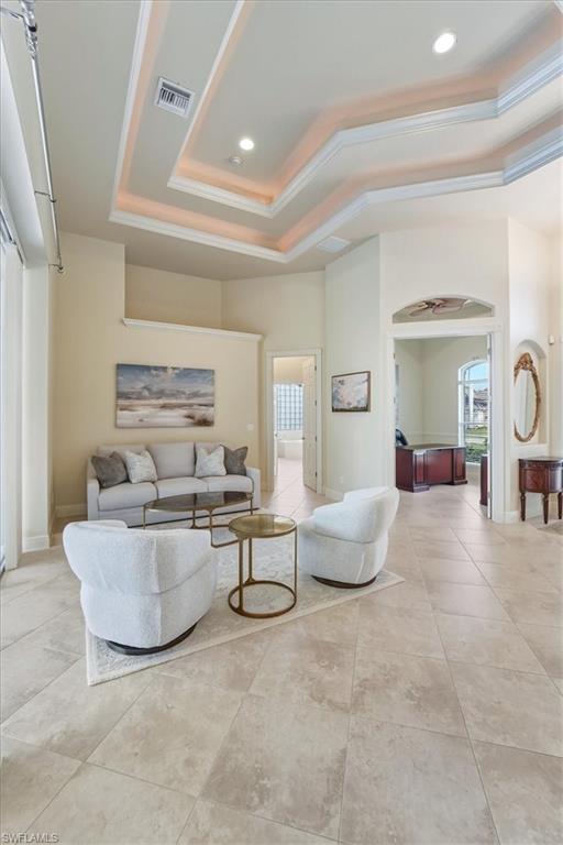 560 Inlet Drive Marco Island, FL 34145 - Photo 8 of 32 Living area featuring a raised ceiling, crown molding, arched walkways, light tile patterned floors, and recessed lighting