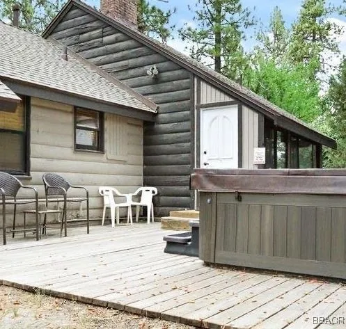 a view of a house with a balcony and wooden bench in a patio