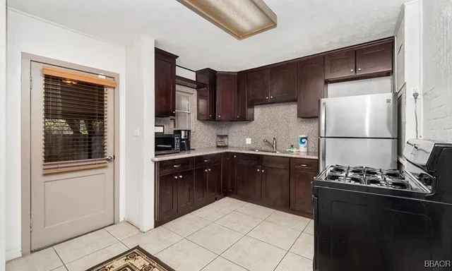 a kitchen with a refrigerator and a stove top oven