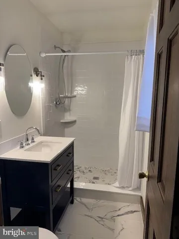 a bathroom with a tub sink and mirror