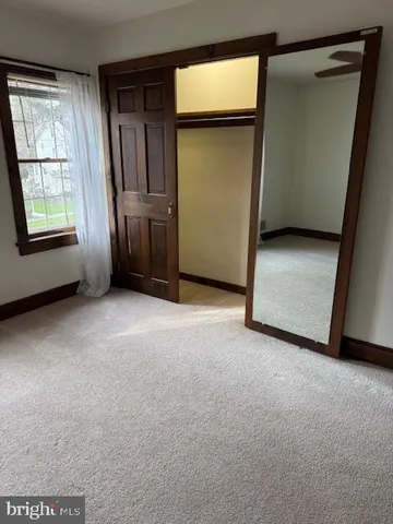a view of an empty room with a fireplace and a window
