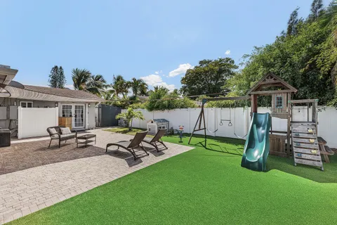 a view of a patio with table and chairs with wooden floor and fence
