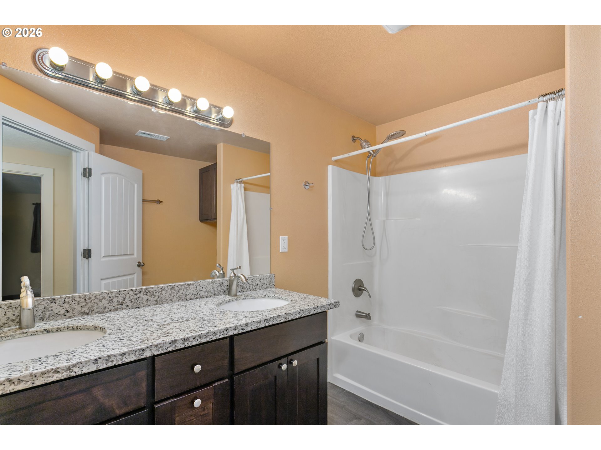 23575 East Gumjuwac Road Welches, OR 97067 - Photo 25 of 48 a bathroom with a granite countertop sink a large mirror and a bathtub