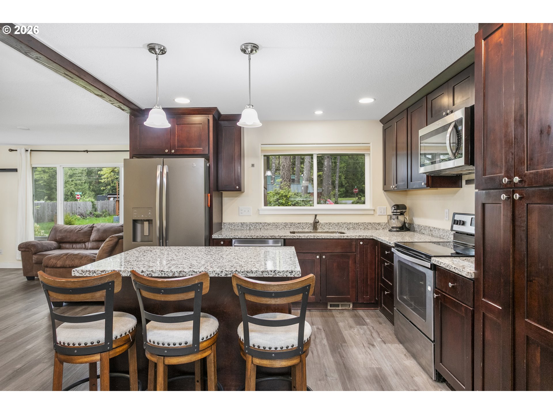 23575 East Gumjuwac Road Welches, OR 97067 - Photo 6 of 48 a kitchen with a dining table chairs stainless steel appliances and cabinets