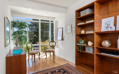 a living room with furniture and a floor to ceiling window