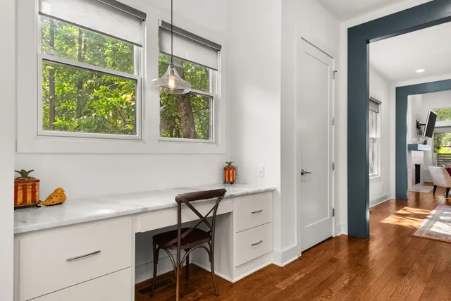 a view of a workspace with furniture and a window